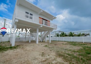 Front view of a newly built 2-bedroom concrete home in San Pedro, Belize, featuring a modern design and welcoming entrance