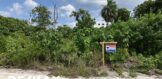 Buying land in belize. remax sign on a beachfront lot