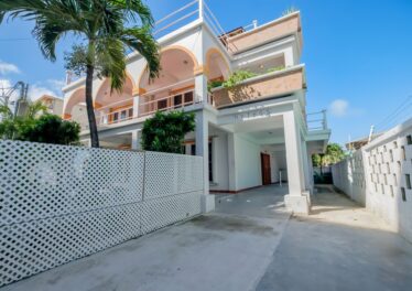 Front view of Mythos 3-unit concrete building in San Pedro, Belize, featuring modern design and a well-maintained exterior.