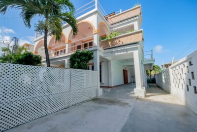 Front view of Mythos 3-unit concrete building in San Pedro, Belize, featuring modern design and a well-maintained exterior.