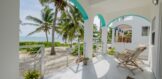 Stunning view from the balcony of a 2-bedroom, 2-bath home for sale in North Ambergris Caye, overlooking the pristine beach and crystal-clear Caribbean waters