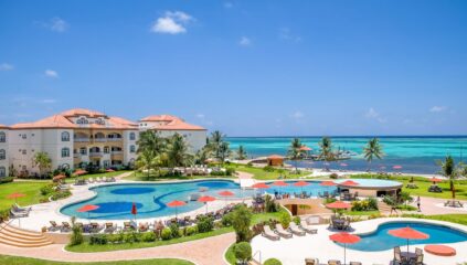 Panoramic view of Grand Caribe Resort in Ambergris Caye, Belize, featuring lush tropical landscaping, beachfront pools, and stunning Caribbean ocean views