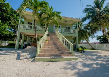 Front view of Casa Sur, a charming duplex for sale on South Ambergris Caye, showcasing the well-maintained exterior and spacious lot