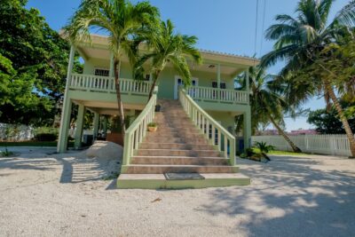 Front view of Casa Sur, a charming duplex for sale on South Ambergris Caye, showcasing the well-maintained exterior and spacious lot