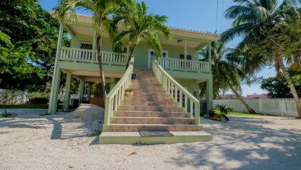 Front view of Casa Sur, a charming duplex for sale on South Ambergris Caye, showcasing the well-maintained exterior and spacious lot