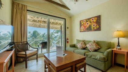 View from living room through glass doors to balcony, showcasing stunning Caribbean Sea views from the oceanfront condo in San Pedro, Ambergris Caye