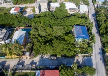 Aerial view of two side-by-side Ambergris Caye canal lots for sale, showcasing their prime location with easy access to the reef and surrounding island features