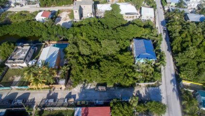 Aerial view of two side-by-side Ambergris Caye canal lots for sale, showcasing their prime location with easy access to the reef and surrounding island features