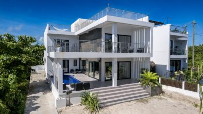 Front view of Everblue Villa, a luxurious beachfront home in Ambergris Caye, Belize, featuring modern architecture and spacious outdoor areas